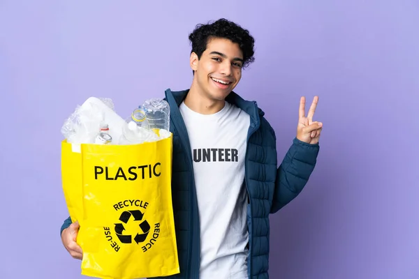Молодий Венесуельський Чоловік Тримає Сумку Пластиковими Пляшками Посміхаючись Показуючи Знак — стокове фото
