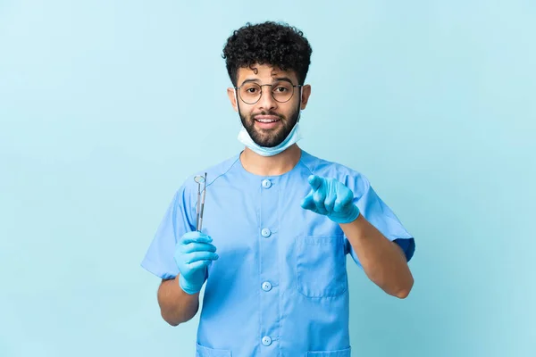 Homem Dentista Marroquino Segurando Ferramentas Isoladas Fundo Azul Surpreso Apontando — Fotografia de Stock