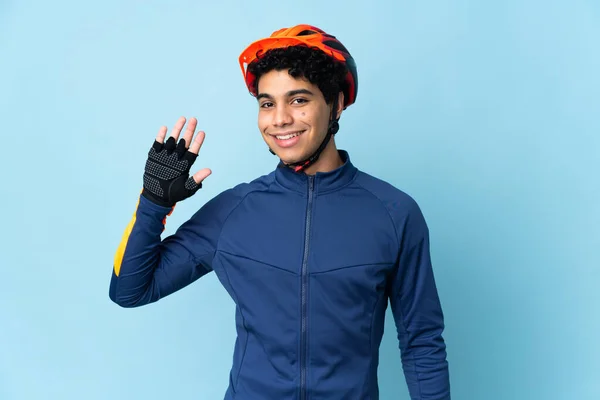 Hombre Ciclista Venezolano Aislado Sobre Fondo Azul Saludando Con Mano — Foto de Stock