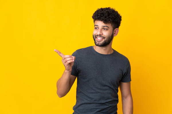 Young Moroccan man isolated on yellow background intending to realizes the solution while lifting a finger up