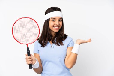 İzole edilmiş beyaz arkaplan üzerinde genç badminton oyuncusu kadın bir reklam eklemek için avucunda hayali bir metin tutuyor.