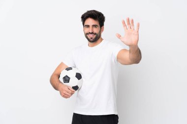 Sakallı yakışıklı genç adam izole edilmiş beyaz arka planda mutlu bir ifadeyle selam veriyor.