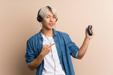 Video oyunlarında oynayan Asyalı genç adam izole edilmiş arka planda