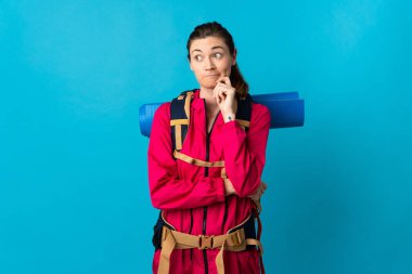 Genç dağcı kadın soyutlanmış mavi arka planda kuşkuları ve düşünceleri var.