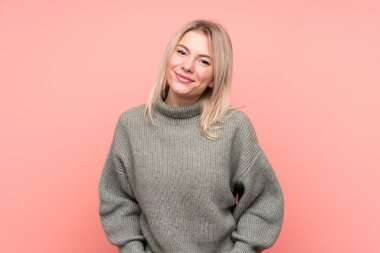 Soyutlanmış pembe arka plan gülüşü olan genç sarışın Rus kadın.