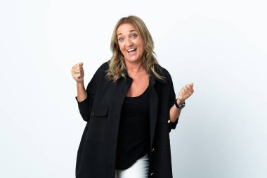 Orta yaşlı sarışın kadın izole edilmiş beyaz arka planda zaferi kutluyor.