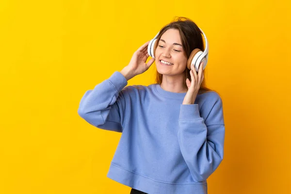 Genç Rlandalı Kadın Sarı Arka Planda Izole Edilmiş Müzik Dinliyor — Stok fotoğraf