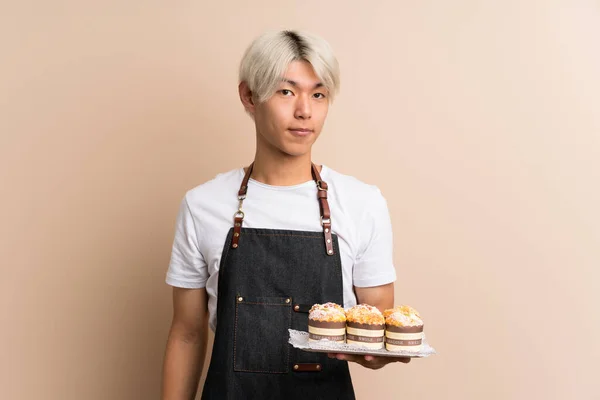 Joven Asiático Hombre Sobre Aislado Fondo Holding Mini Pasteles —  Fotos de Stock