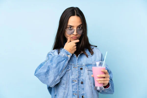 Jovem Com Batido Morango Sobre Fundo Azul Isolado Pensando — Fotografia de Stock