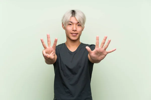 Mladý Asijský Muž Přes Izolované Zelené Pozadí Počítání Osm Prsty — Stock fotografie