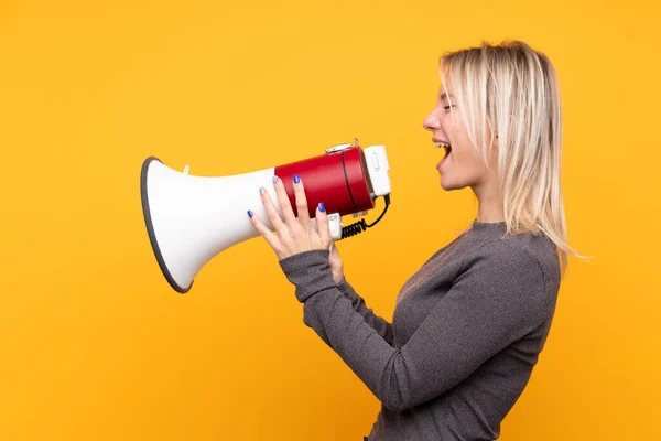 Jonge Blonde Vrouw Geïsoleerde Gele Achtergrond Schreeuwen Door Een Megafoon — Stockfoto