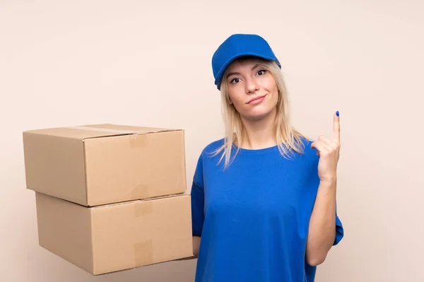 Young delivery woman over isolated background pointing with the index finger a great idea