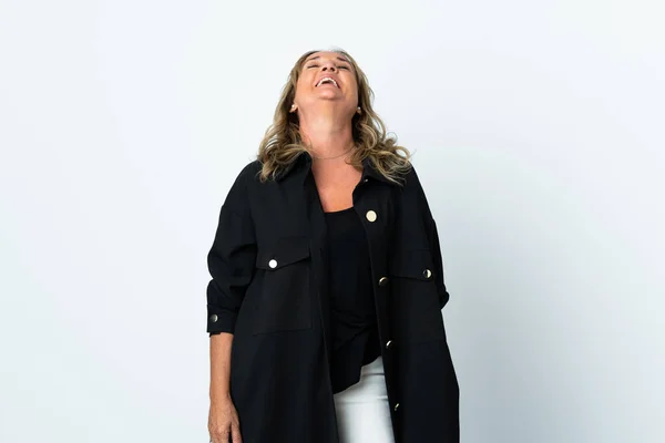 Middle aged blonde woman over isolated white background laughing in lateral position