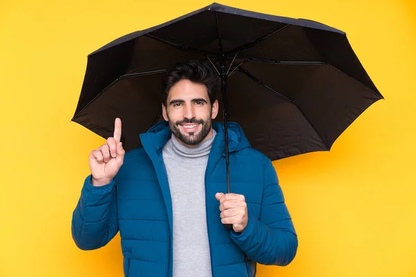 孤立した黄色の背景の上に傘を持っている男素晴らしいアイデアを指摘 — ストック写真