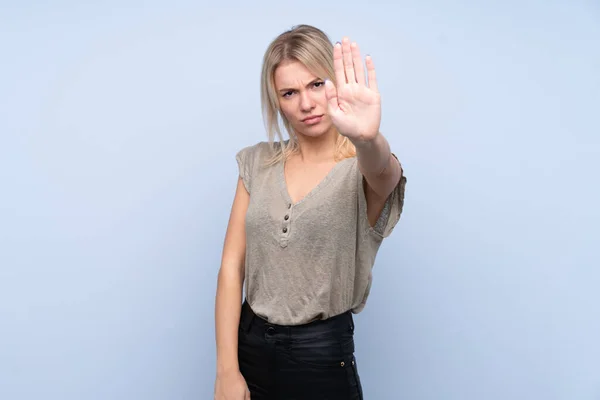 Mujer Rubia Joven Sobre Fondo Azul Aislado Haciendo Gesto Parada —  Fotos de Stock