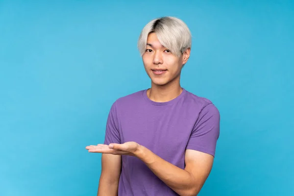 Junger Asiatischer Mann Auf Isoliertem Blauem Hintergrund Präsentiert Eine Idee — Stockfoto