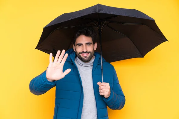 Homem Segurando Guarda Chuva Sobre Fundo Amarelo Isolado Saudando Com — Fotografia de Stock