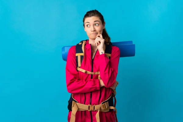 Jonge Bergbeklimmer Vrouw Geïsoleerde Blauwe Achtergrond Met Twijfels Denken — Stockfoto