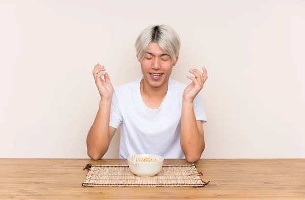 若いですアジア人男性とラーメンをテーブルの上で笑って — ストック写真