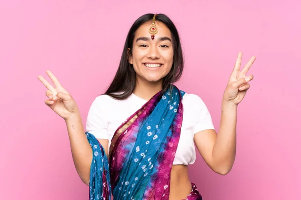 Young Indian woman with sari over isolated background showing victory sign with both hands