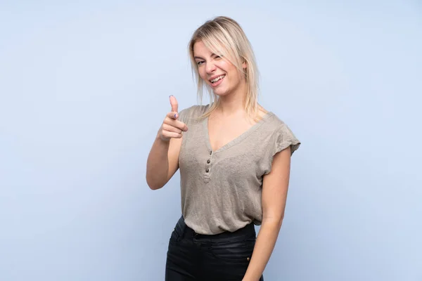Ung Blond Kvinna Över Isolerad Blå Bakgrund Pekar Finger Dig — Stockfoto