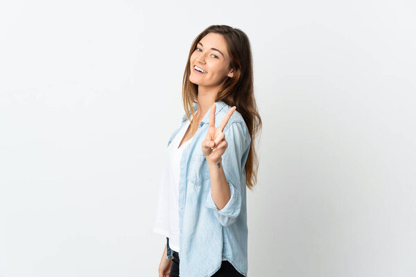 Молодая Ирландия женщина изолированы на белом фоне улыбаясь и показывая знак победы