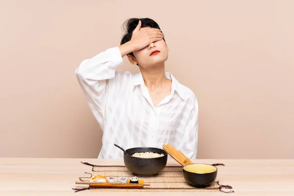 Młoda Azjatka Stole Miską Makaronu Sushi Okrywające Oczy Dłońmi — Zdjęcie stockowe