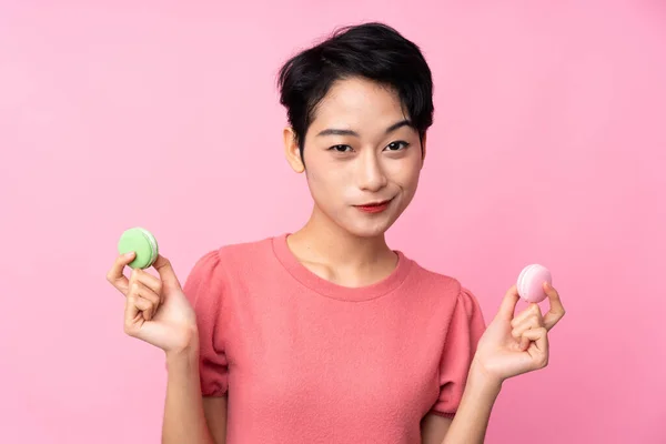 Mladá Asijská Dívka Přes Izolované Růžové Pozadí Drží Barevné Francouzské — Stock fotografie