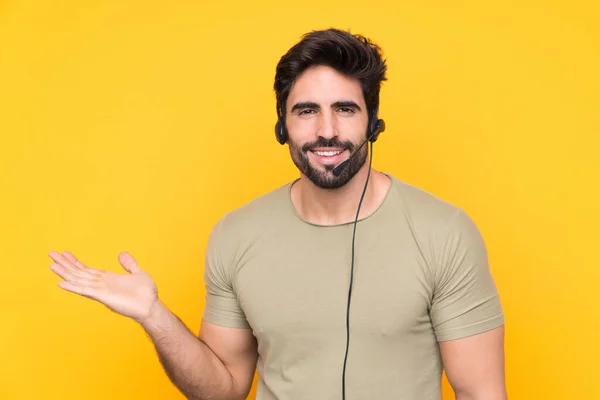 Hombre Telemarketer Trabajando Con Auricular Sobre Fondo Amarillo Aislado Sosteniendo — Foto de Stock