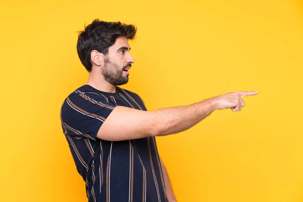 Jovem Homem Bonito Com Barba Sobre Fundo Amarelo Isolado Apontando — Fotografia de Stock