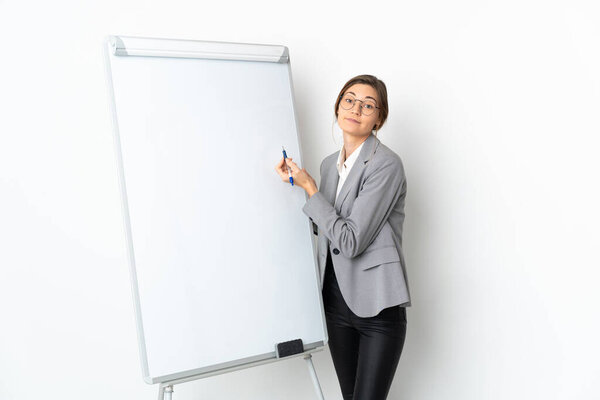 Young Ireland woman isolated on white background giving a presentation on white board