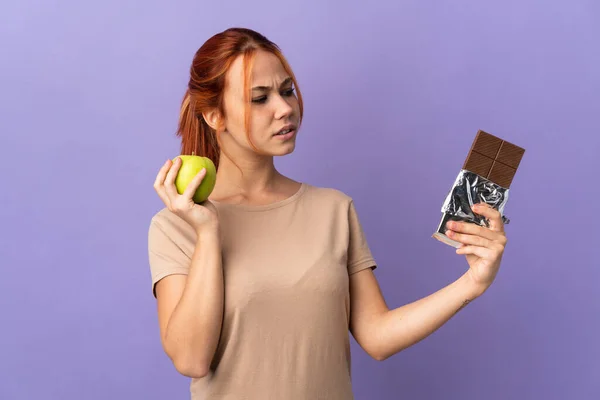 Teenager Ruské Dívka Izolované Fialovém Pozadí Pochybnostmi Při Užívání Čokoládové — Stock fotografie