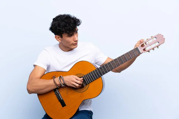 Junger Argentinier Mit Gitarre Vor Isoliertem Blauen Hintergrund — Stockfoto