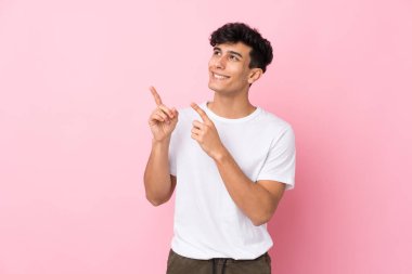 Arjantinli genç adam izole edilmiş pembe arka planda işaret parmağı harika bir fikir.