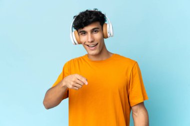 Arjantinli genç adam arka planda izole edilmiş müzik dinliyor.