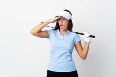 İzole edilmiş beyaz arka planda genç golfçü kadın yan tarafa bakarken sürpriz jest yapıyor.