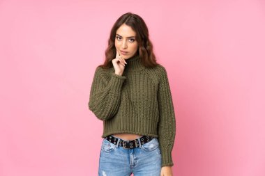 Soyutlanmış pembe arka planda genç bir kadın.
