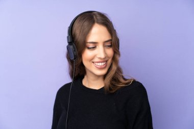 Soyutlanmış mor arka plan müzik dinleyen genç bir kadın.