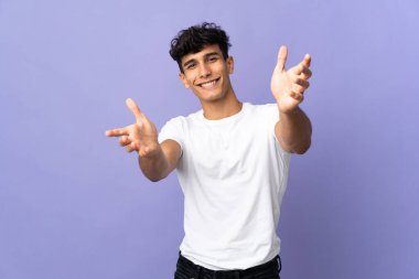 Arjantinli genç adam arka planda izole edilmiş sunum yapıyor ve davet ediyor.