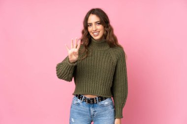 Soyutlanmış pembe arka planı olan genç bir kadın mutlu ve parmakları olan dört kişi sayıyor.