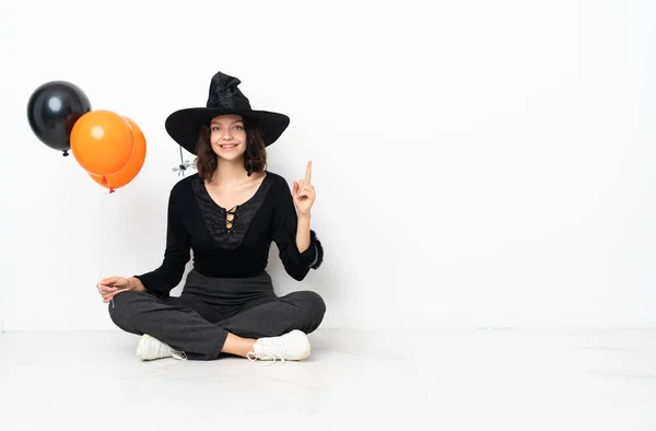 Joven Bruja Sosteniendo Globos Aire Negro Naranja Sentada Suelo Señalando —  Fotos de Stock