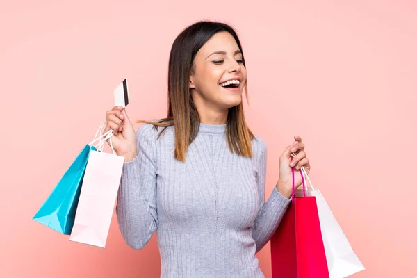 Kvinna Över Isolerad Rosa Bakgrund Med Shoppingväskor Och Ett Kreditkort — Stockfoto