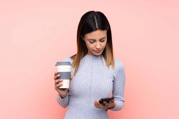 Vrouw Geïsoleerde Roze Achtergrond Houden Koffie Mee Nemen Een Mobiele — Stockfoto