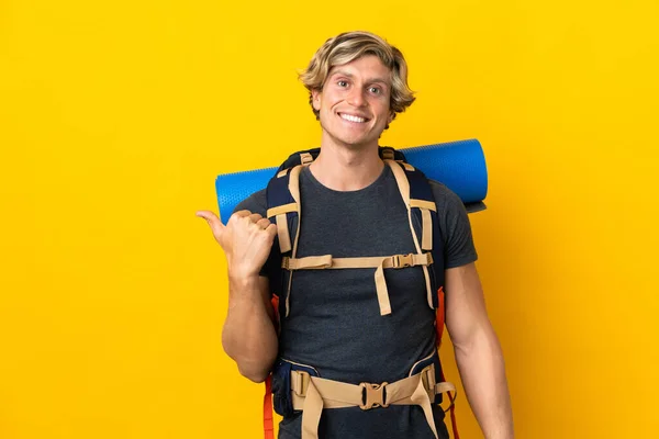 Mladý Horolezec Muž Přes Izolované Žluté Pozadí Ukazuje Strany Prezentovat — Stock fotografie
