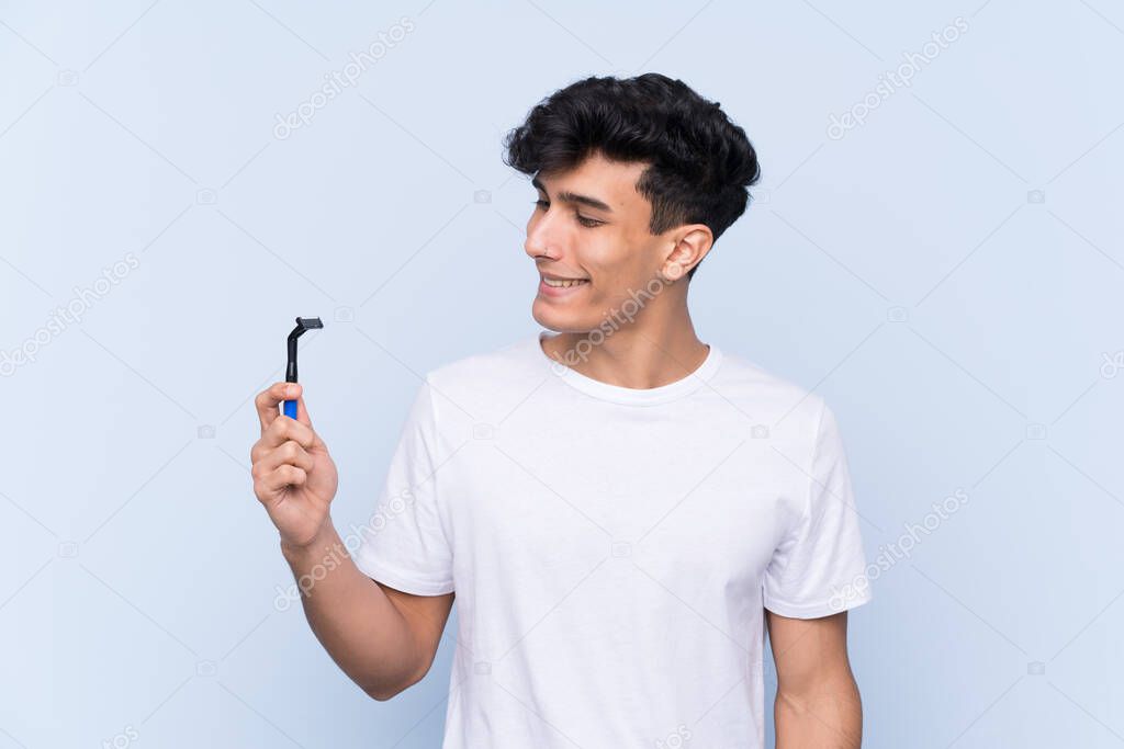 Man shaving his beard over isolated white background with happy expression