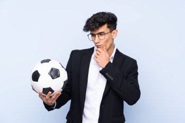 Arjantinli futbol koçu hüzünlü bir ifadeyle izole edilmiş mavi arka plan üzerinden