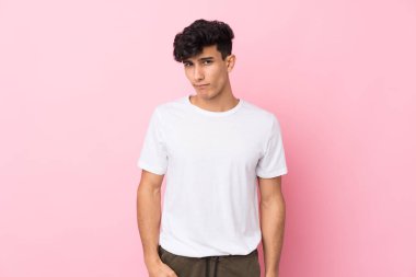 Arjantinli genç adam soyutlanmış pembe arka plan üzgün