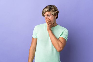 Soyutlanmış mor arka planda İngiliz bir adam. Yan tarafa bakarken sürpriz bir jest yapıyor.