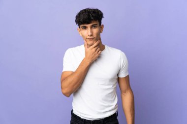 Arjantinli genç adam arka planda izole edilmiş düşünüyor.