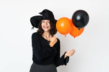 Siyah ve turuncu hava balonları tutan genç cadı zaferi kutluyor.